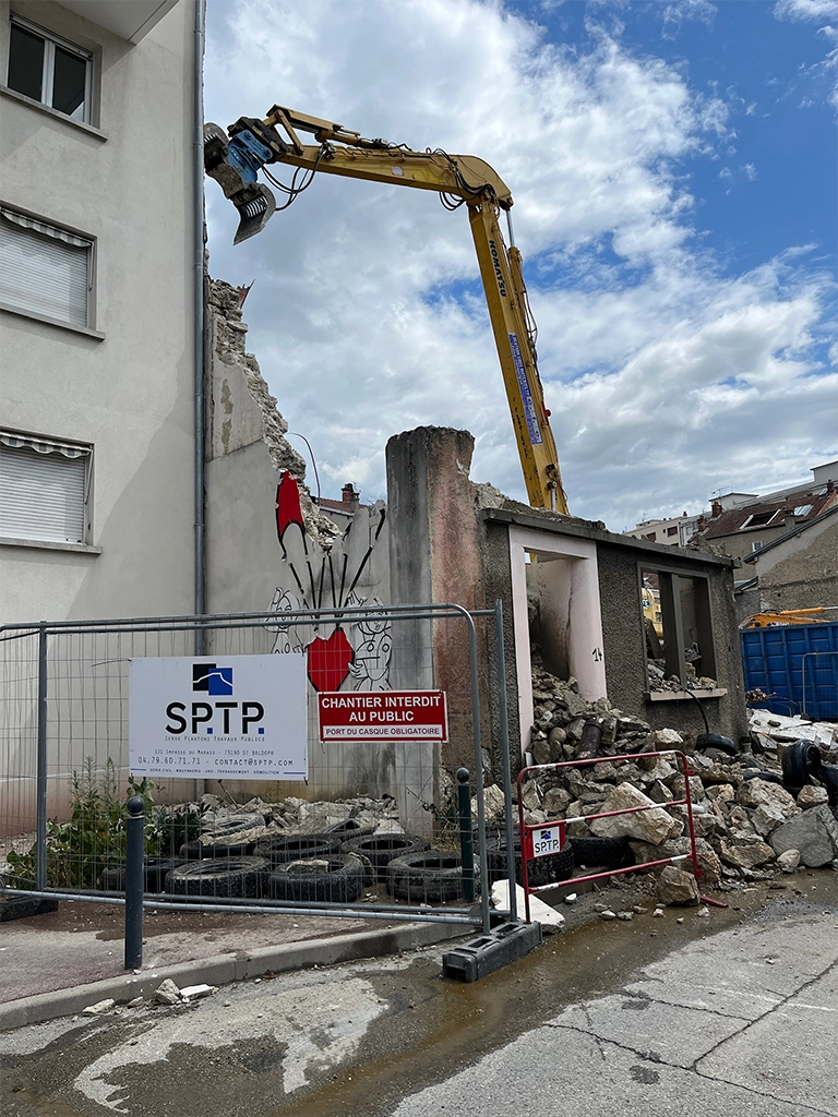 Pelleteuse à pinces en train de déconstruire un immeuble