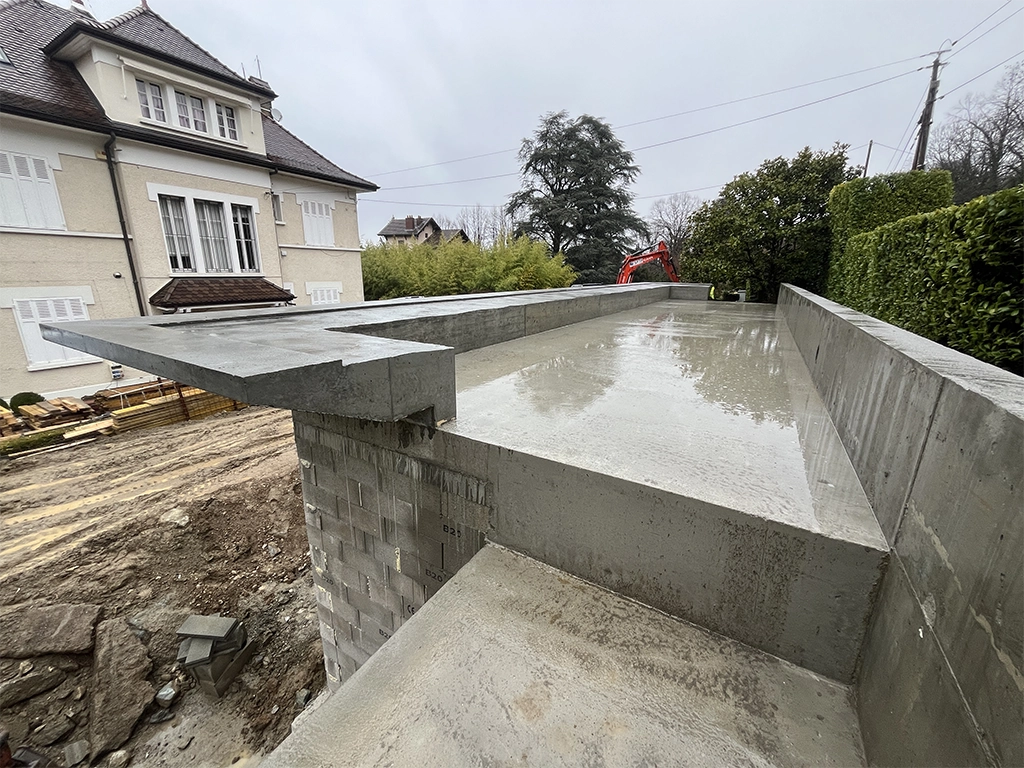 construction maçonné avec une toiture plate en béton et casquette architecturale béton