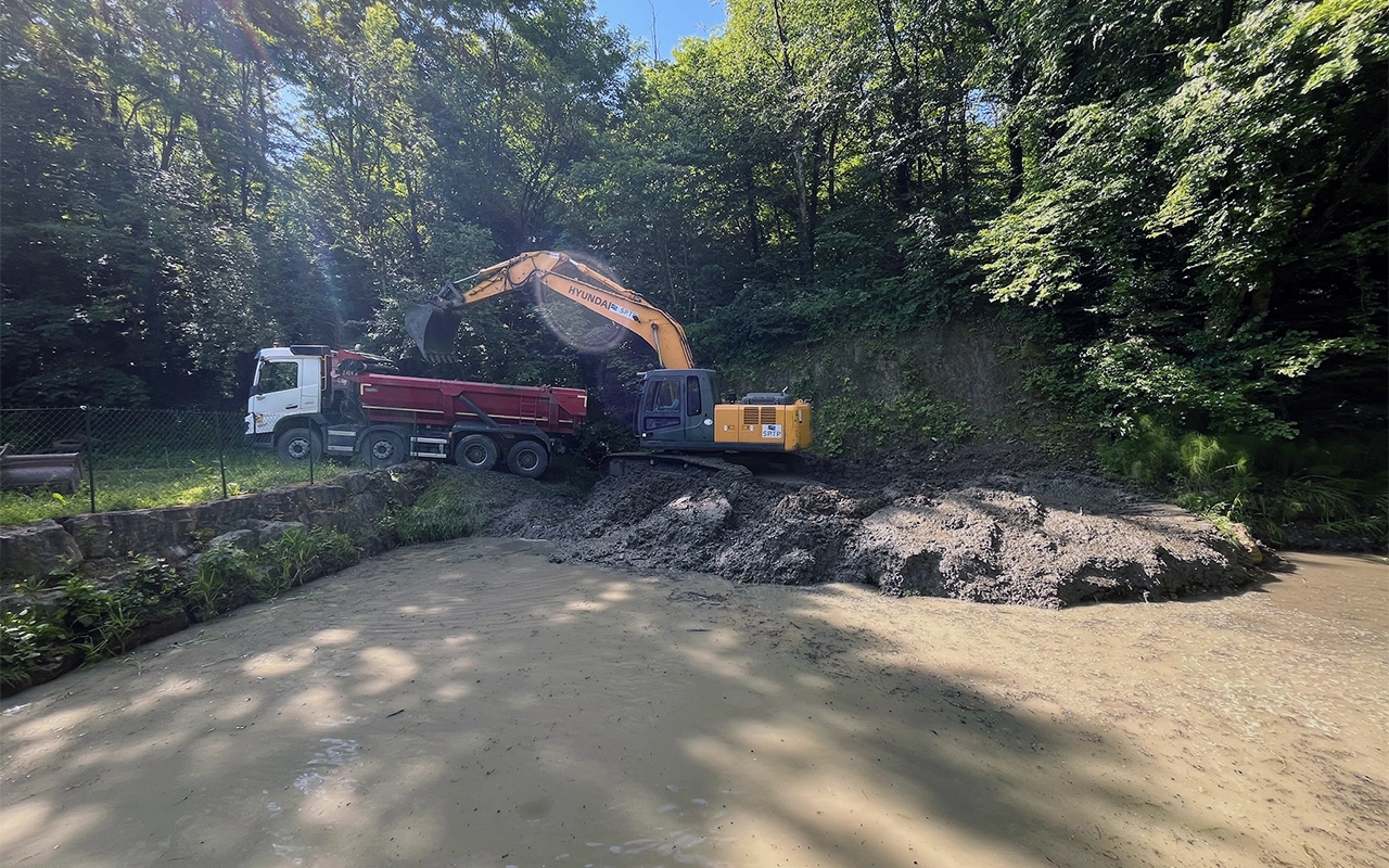 Chantier de curage d'une plage de dépôt  du cours d'eau le Merderet  à Chambéry avec une pelleteuse et un camion 