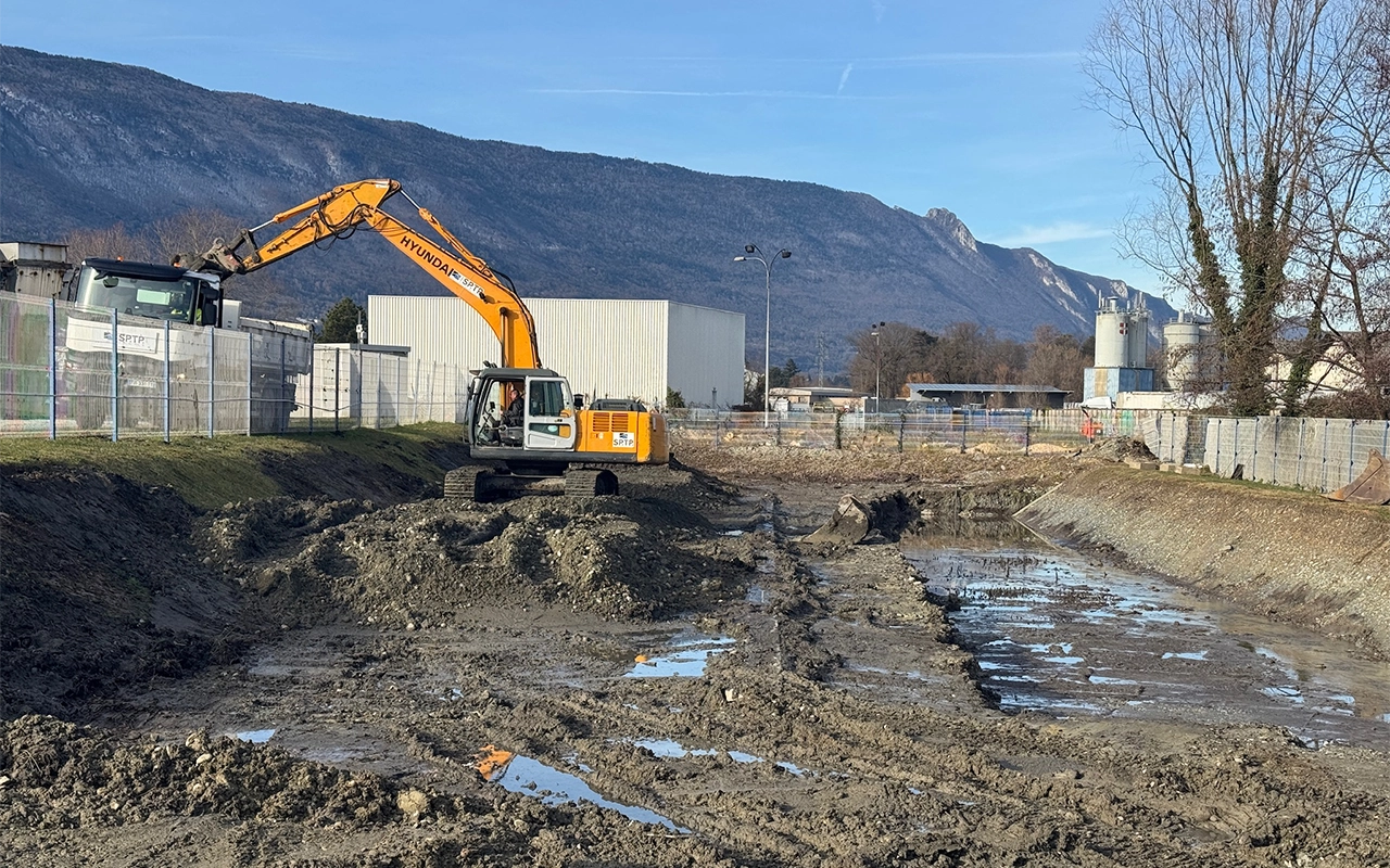 Engin de chantier réalisant un terrassement pour l'usine Placoplâtre à Chambéry en Savoie